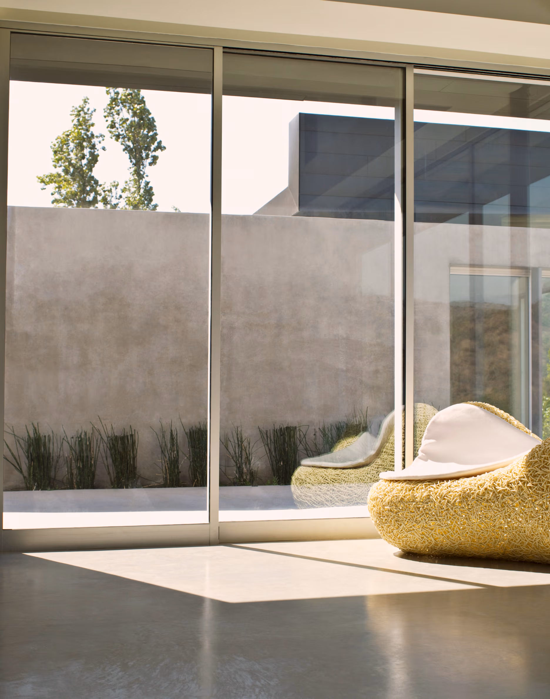 Glass wall of a house with sunlight reflecting on the floors